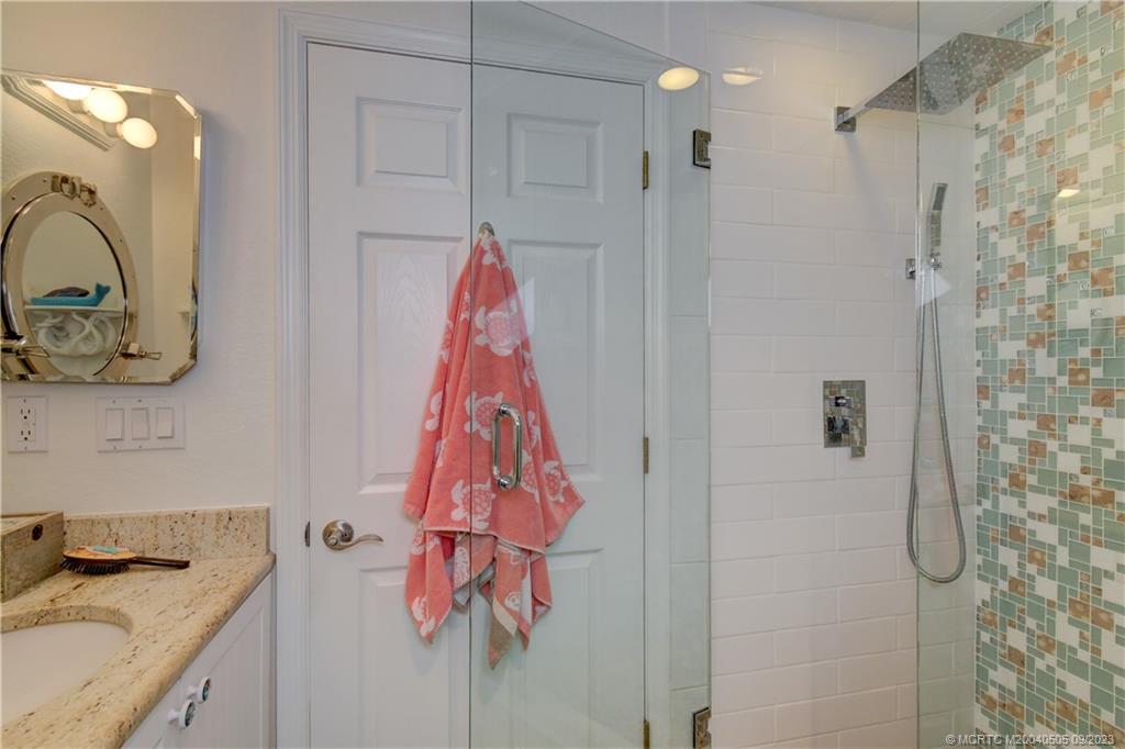 3541 Northeast Ocean Boulevard, Unit 19 Stuart, FL 34996 - Photo 26 of 52 a bathroom with a sink vanity and shower