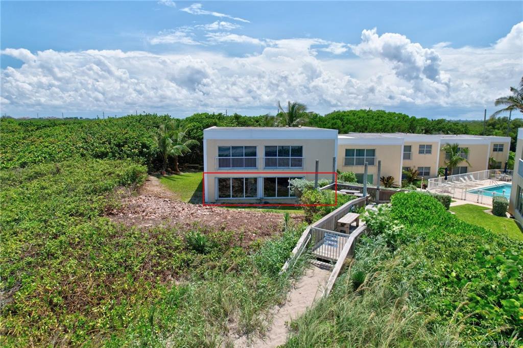 3541 Northeast Ocean Boulevard, Unit 19 Stuart, FL 34996 - Photo 3 of 52 a aerial view of a house with a big yard and potted plants