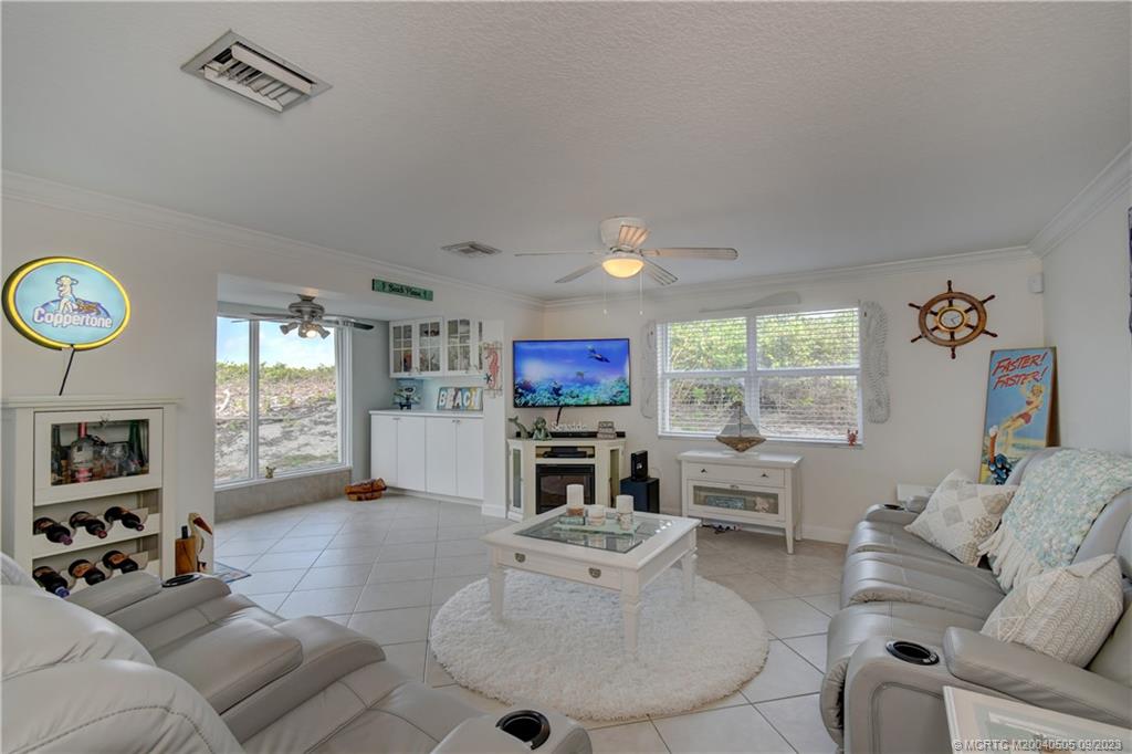 3541 Northeast Ocean Boulevard, Unit 19 Stuart, FL 34996 - Photo 6 of 52 a living room with furniture a fireplace and a flat screen tv
