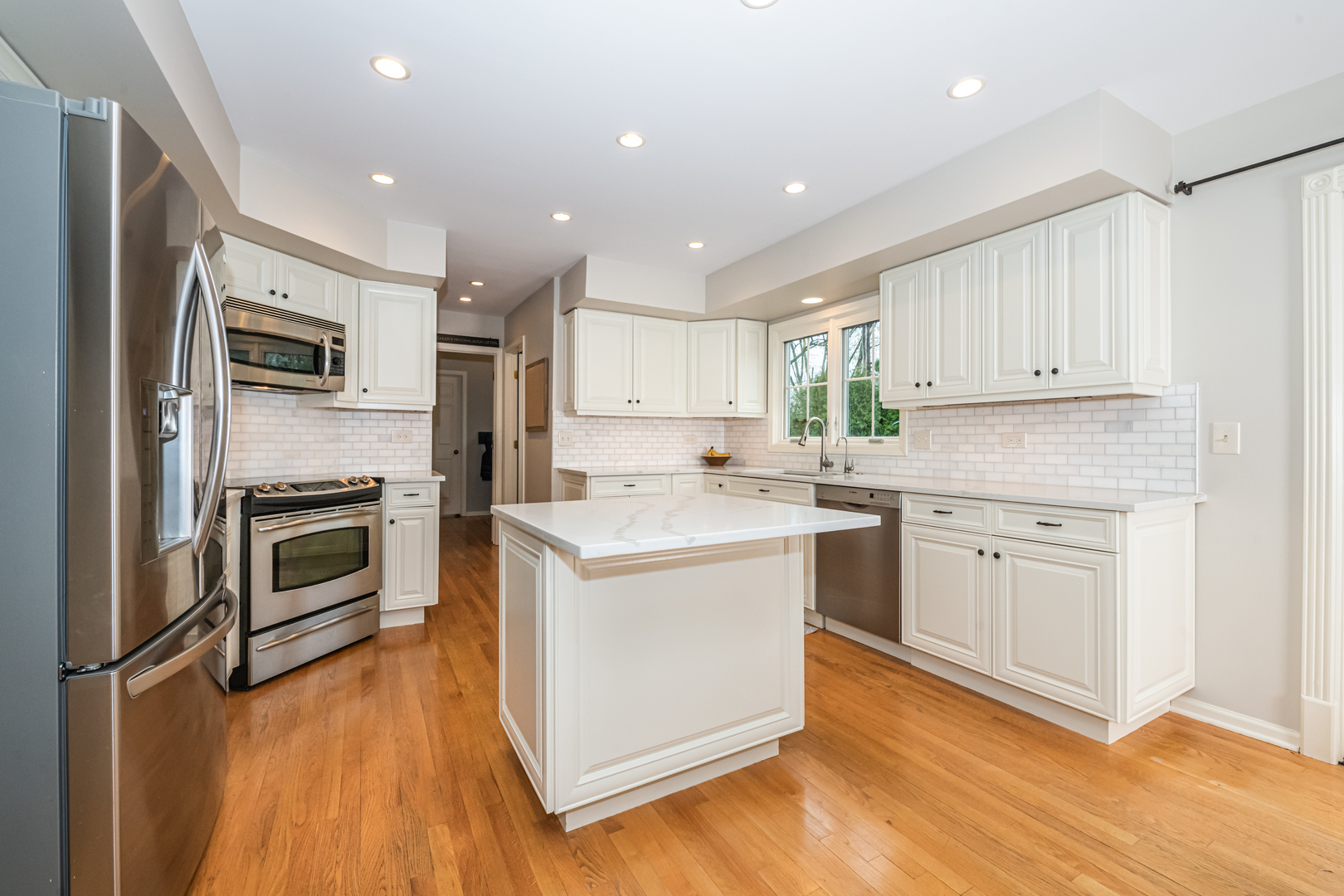 117 Whitney Drive Barrington, IL 60010 - Photo 6 of 37 a kitchen with a sink wooden floor and stainless steel appliances