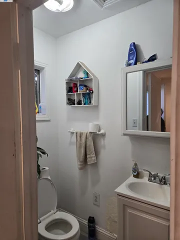 a bathroom with a toilet sink vanity and mirror