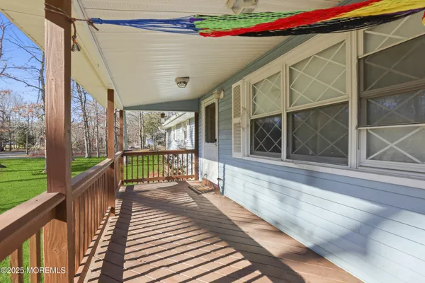a balcony with wooden floor and glass door