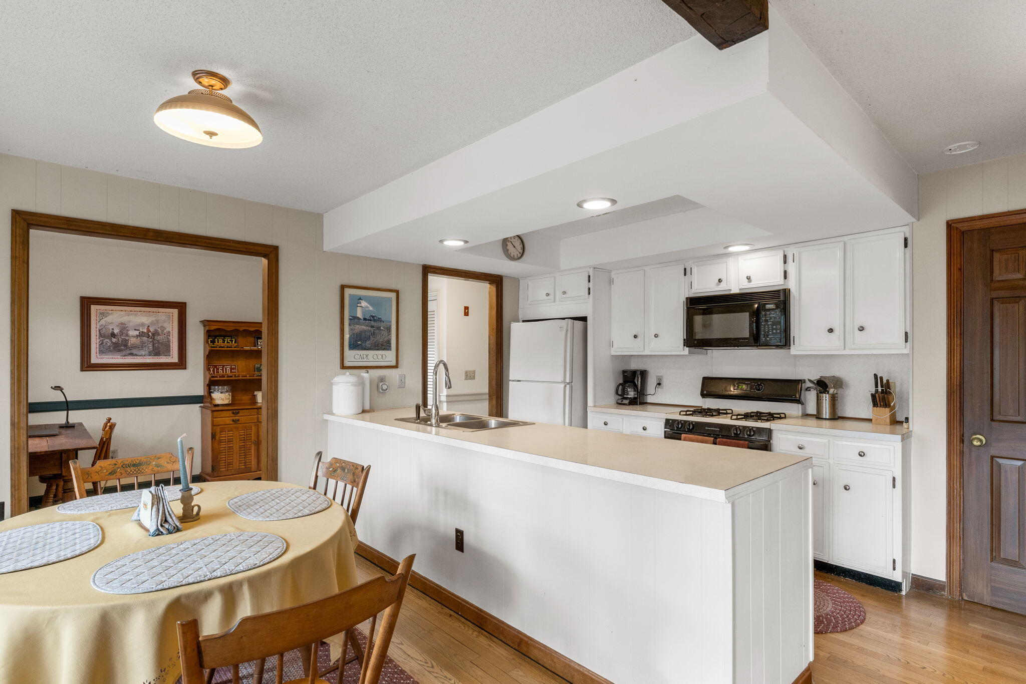 46 Chippingstone Road Chatham, MA 02633 - Photo 13 of 35 a kitchen with stainless steel appliances a stove a sink a microwave a refrigerator a dining table and chairs with wooden floor