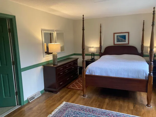 a bedroom with a bed a lamp and window