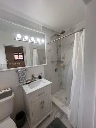 a bathroom with a shower a sink and a mirror