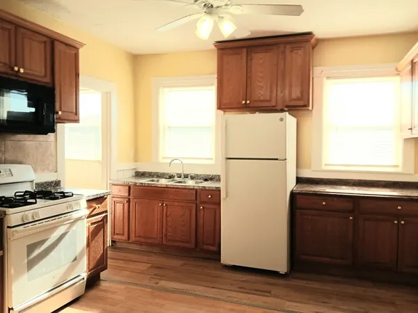 a kitchen with a refrigerator stove and wooden cabinets