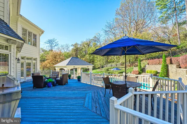 a view of a patio with a table and chairs under an umbrella with wooden fence