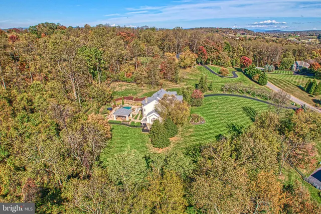 an aerial view of residential houses with outdoor space and trees