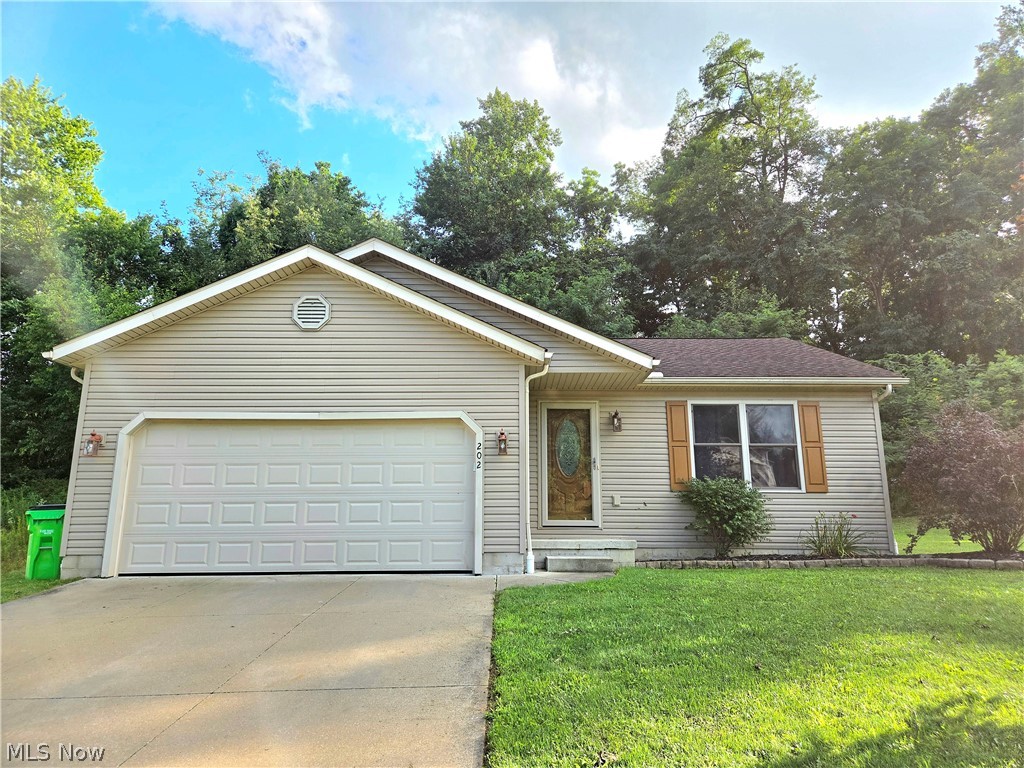 202 Home Street Rittman, OH 44270 - Photo 1 of 23 Single-story residence featuring light-colored siding, an attached garage, and a concrete driveway