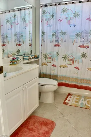 a bathroom with a sink a toilet and shower curtain