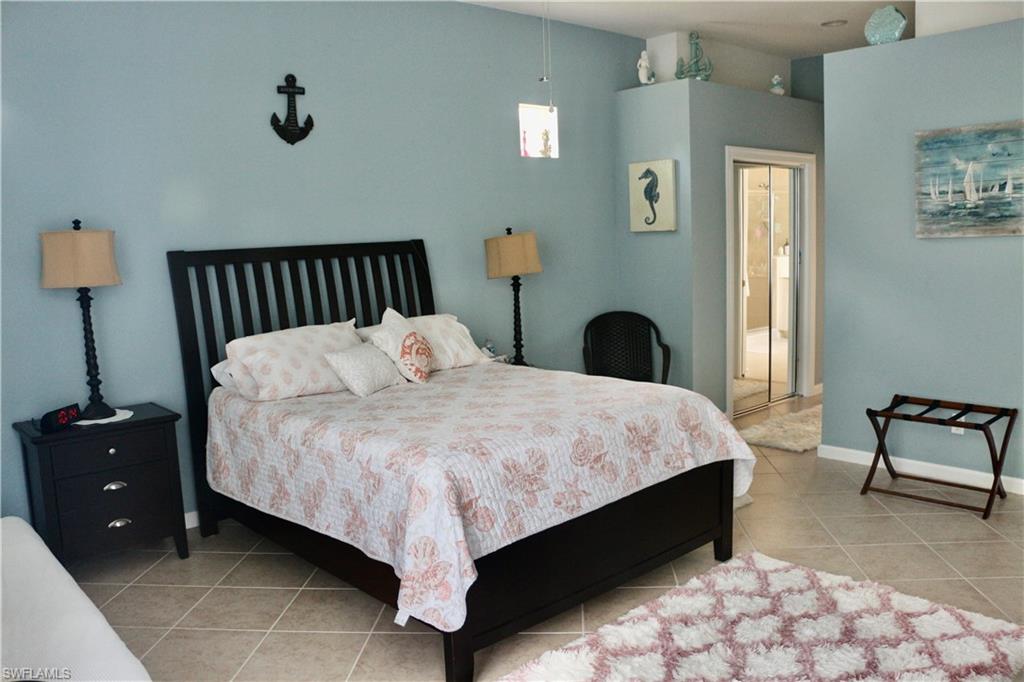16192 Parque Lane Naples, FL 34110 - Photo 14 of 30 a bedroom with a bed and a chair