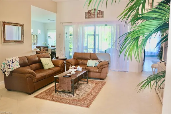 a living room with patio furniture and a potted plant