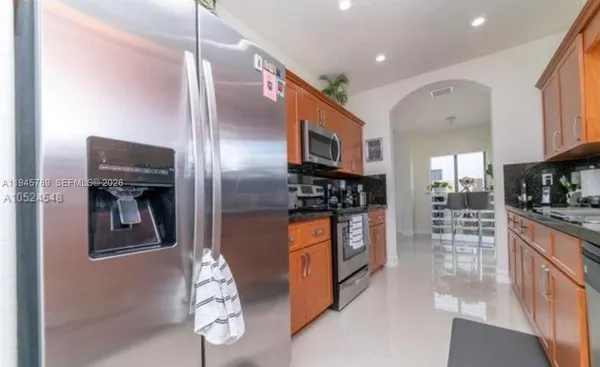 a kitchen with stainless steel appliances granite countertop a refrigerator and a sink
