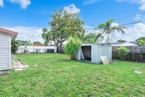 a view of a house with a yard and potted plants
