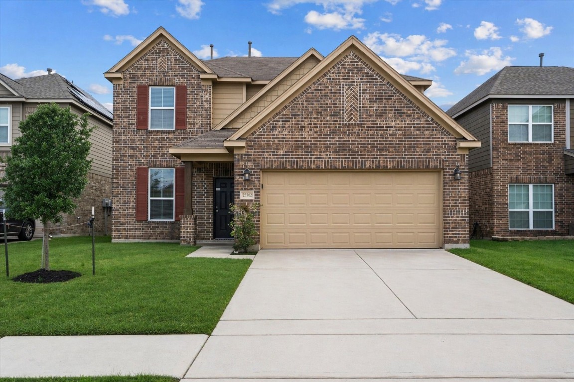 a front view of a house with a yard and garage