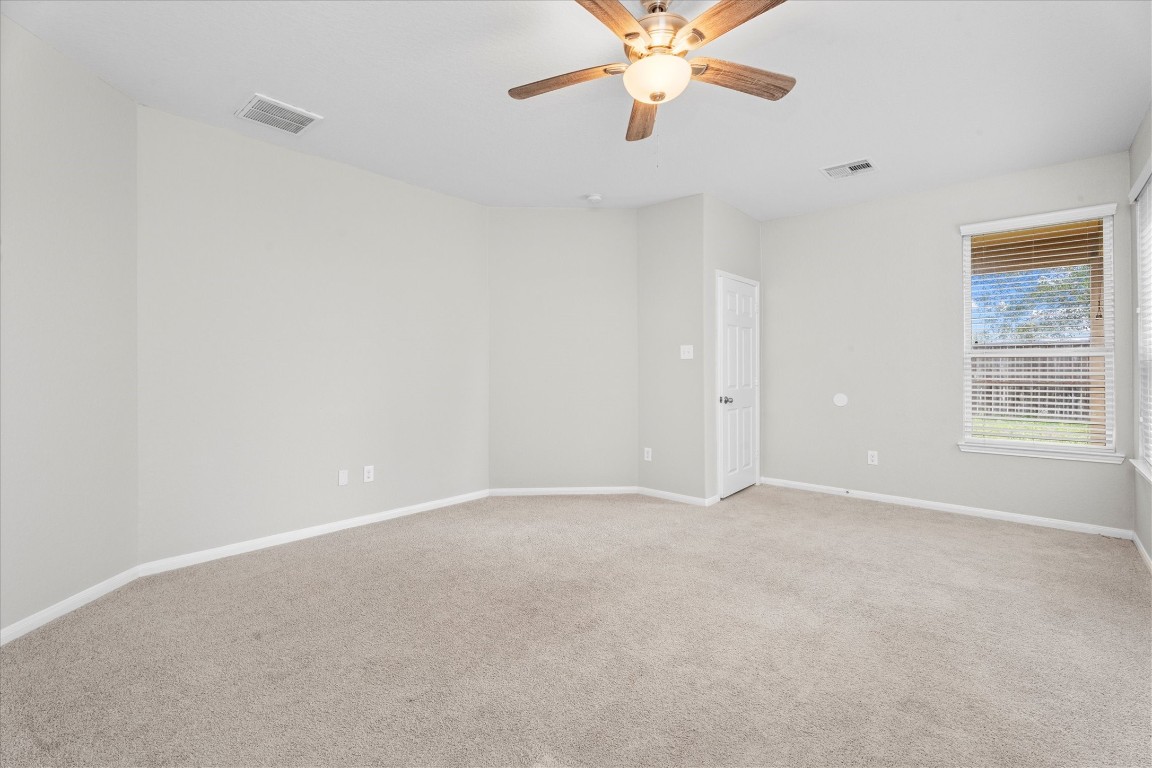 23502 Breckenridge Dale Lane Spring, TX 77373 - Photo 13 of 24 an empty room with a chandelier fan and windows