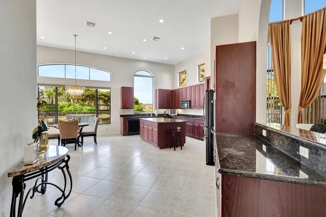 a kitchen with kitchen island a counter top space appliances and a dining table