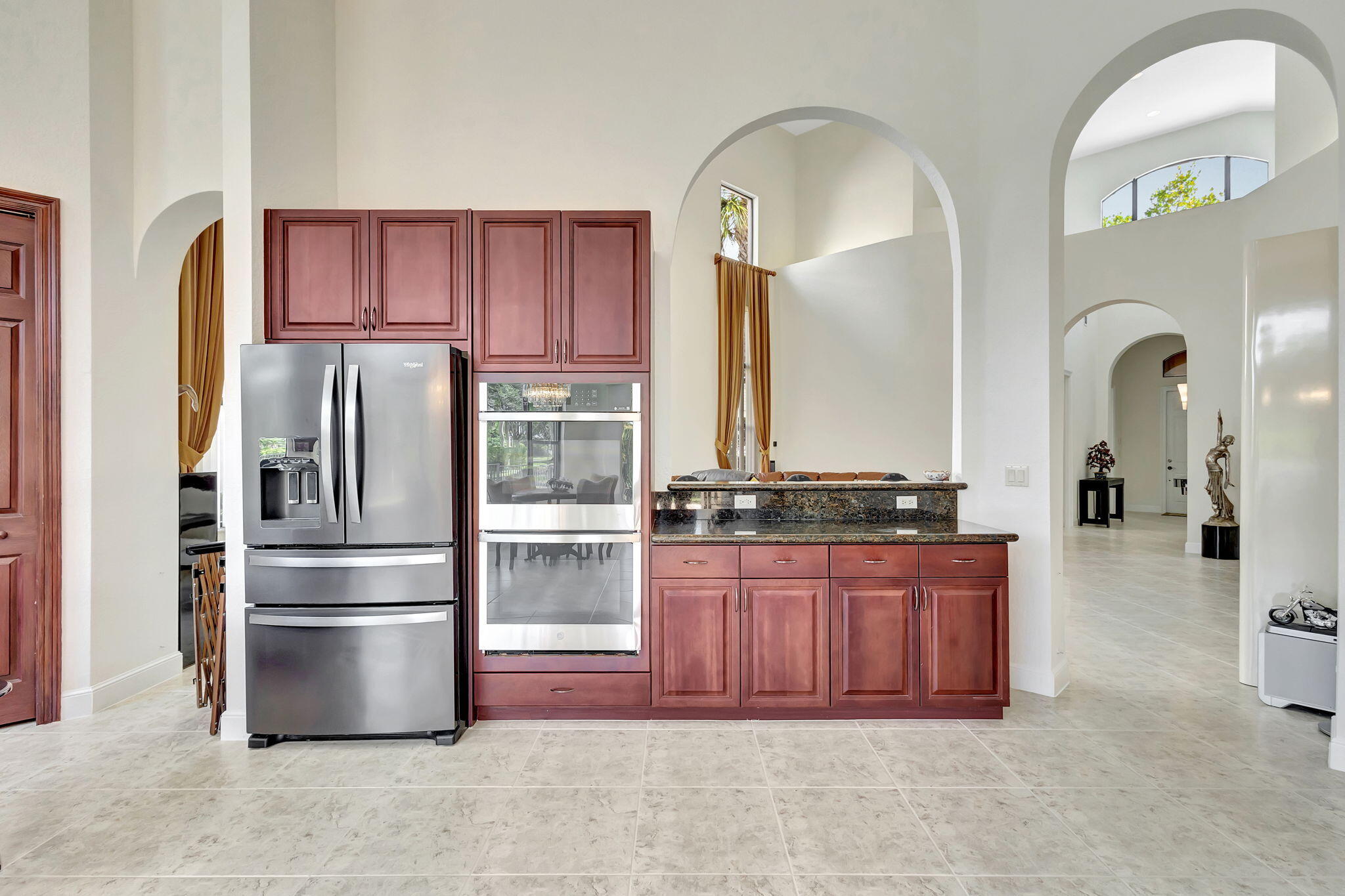 3553 Collonade Drive Wellington, FL 33449 - Photo 16 of 76 a kitchen with stainless steel appliances granite countertop a refrigerator a stove and a sink with wooden cabinets