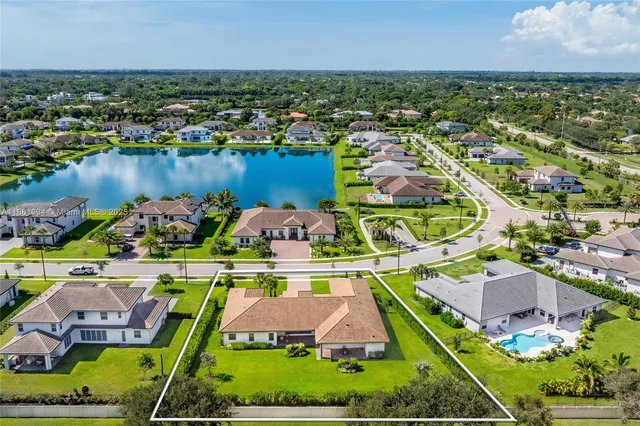 an aerial view of residential houses with outdoor space and lake view