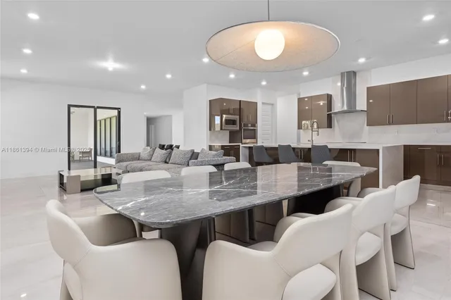 a large kitchen with kitchen island a dining table and chairs