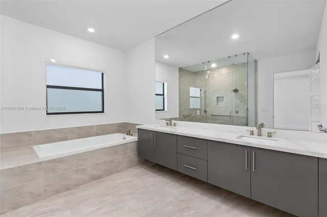 a bathroom with a tub a sink and mirror