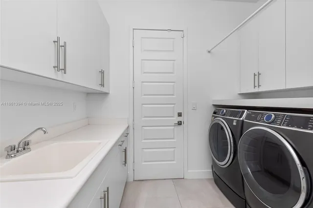 a utility room with sink dryer and washer