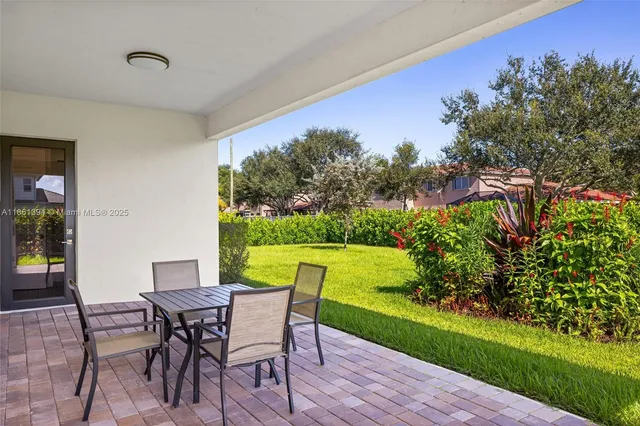 a view of a chairs and table in patio of a yard