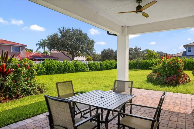 a view of a patio with a table chairs and a yard
