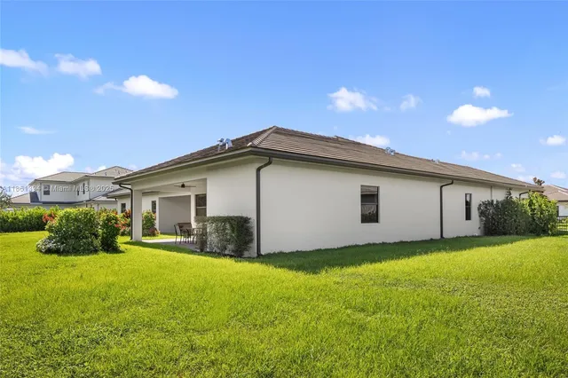 a view of a backyard with plants and large tree