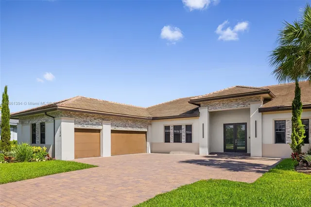 a front view of a house with a garden and yard