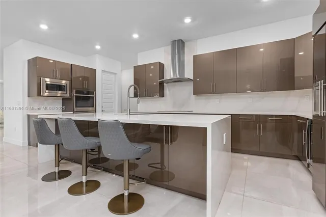 a kitchen with stainless steel appliances kitchen island granite countertop a sink and a microwave