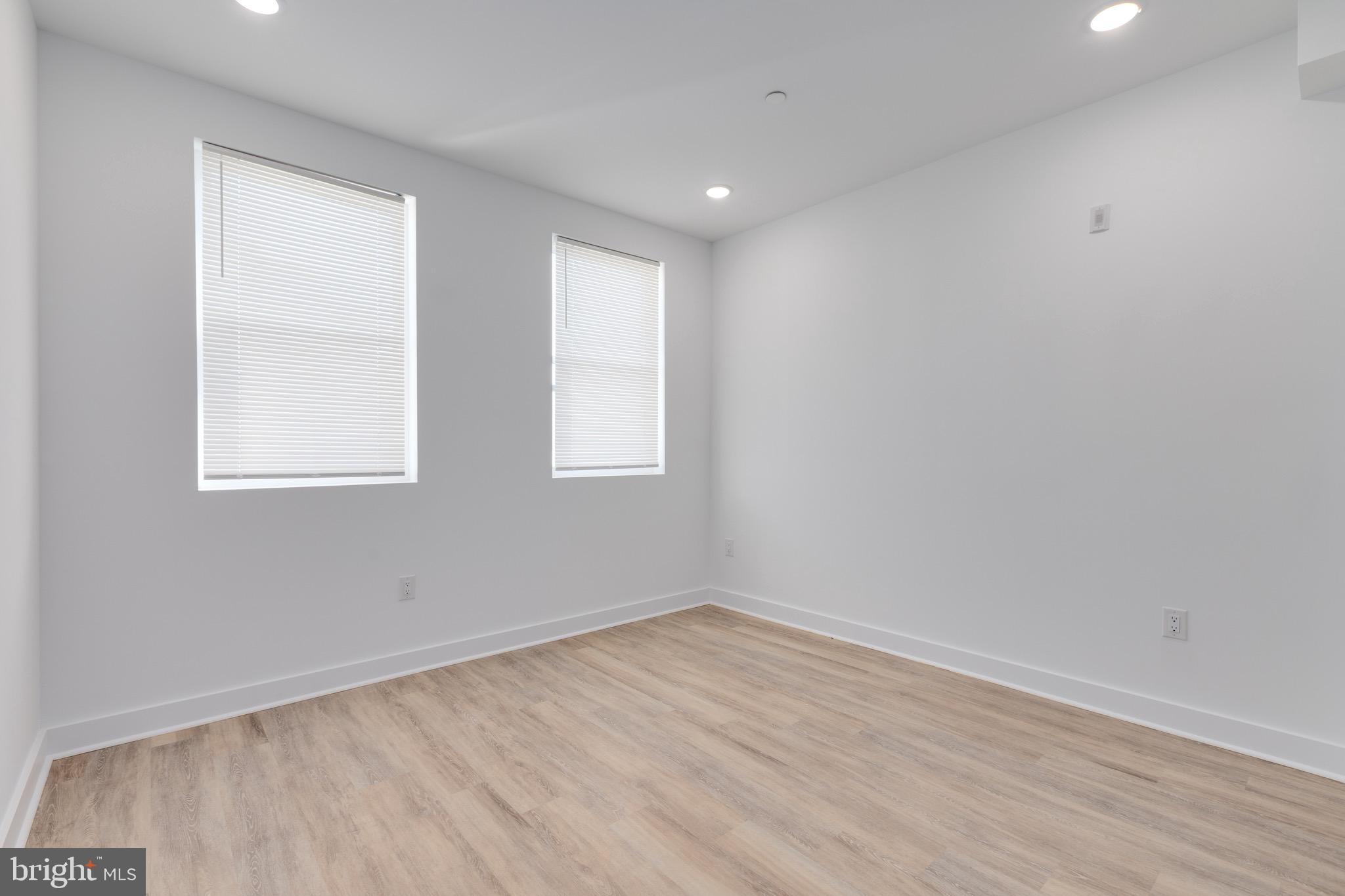 2061 North 8th Street, Unit 2 Philadelphia, PA 19122 - Photo 4 of 11 an empty room with wooden floor and windows