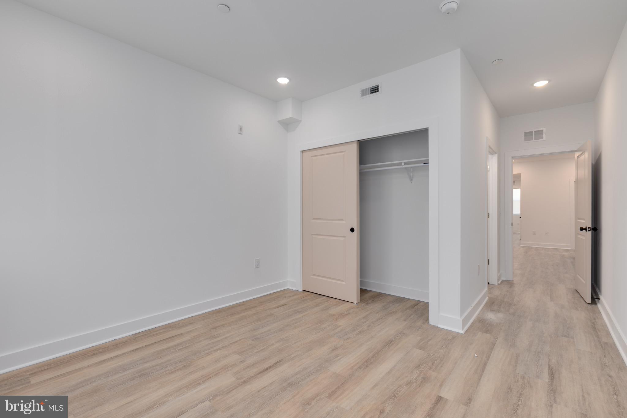 2061 North 8th Street, Unit 2 Philadelphia, PA 19122 - Photo 5 of 11 a view of an empty room with wooden floor and a bathroom
