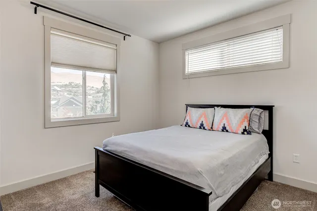 a large bed sitting in a bedroom next to a window