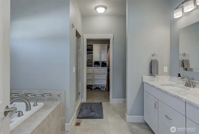 a bathroom with a tub sink and mirror