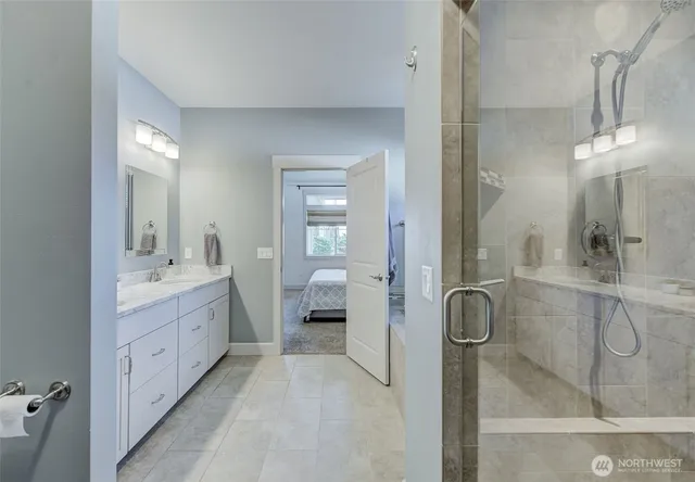 a bathroom with a double vanity sink mirror and shower