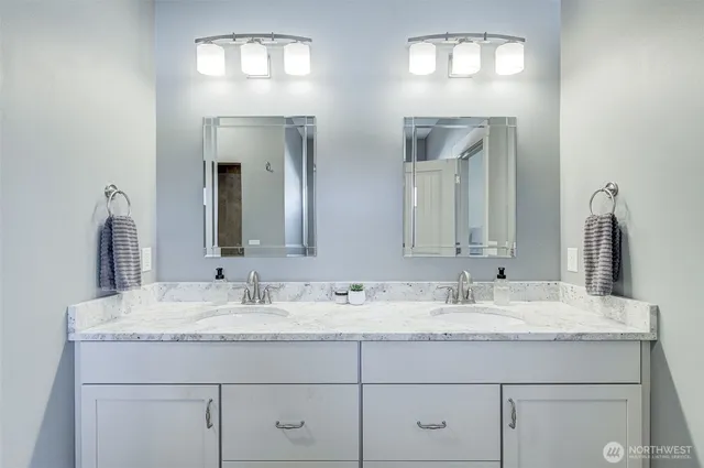 a bathroom with double vanity sinks and a mirror
