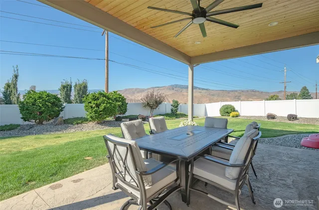 a view of a patio with table and chairs under an umbrella