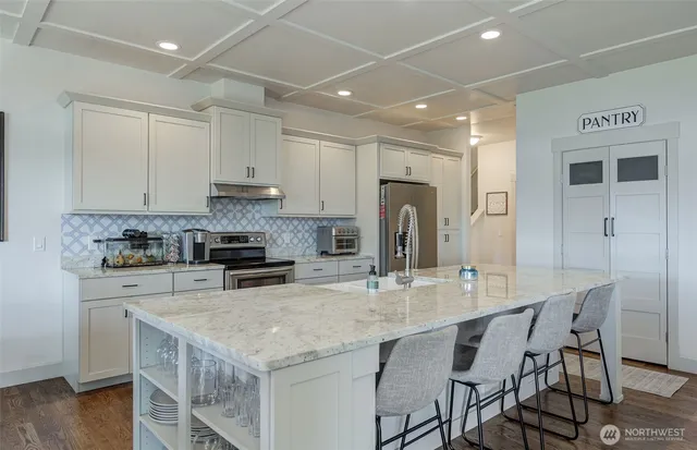 a kitchen with kitchen island a stove a table and chairs in it