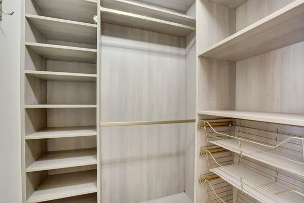 a view of walk in closet with empty racks