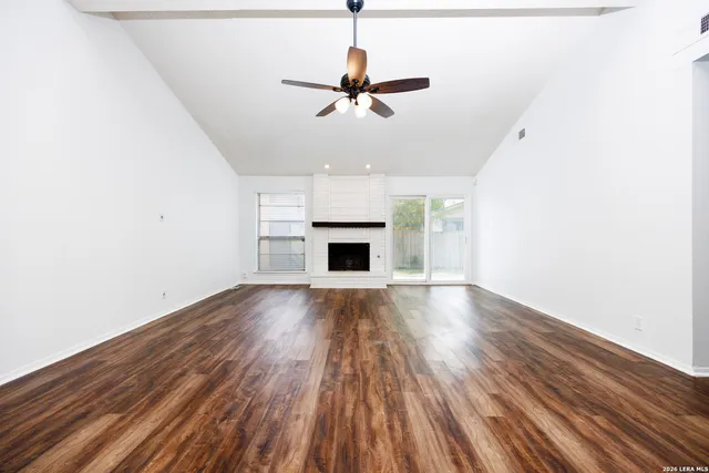 a view of empty room with wooden floor and fireplace