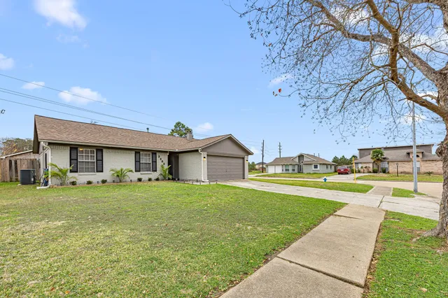 a view of a big house with a big yard and large tree