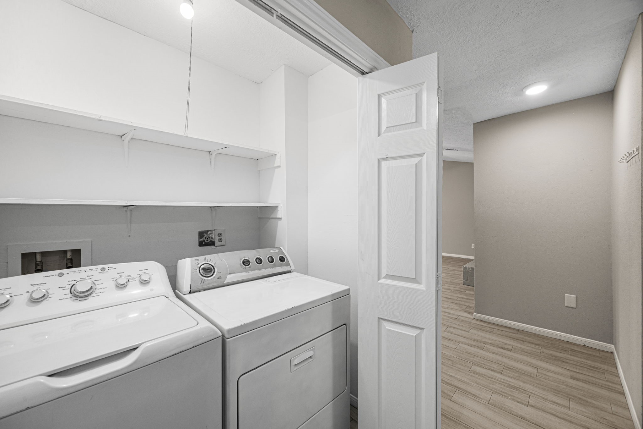 2302 Marble Falls Drive Spring, TX 77373 - Photo 7 of 24 a view of washer and dryer with wooden cabinets