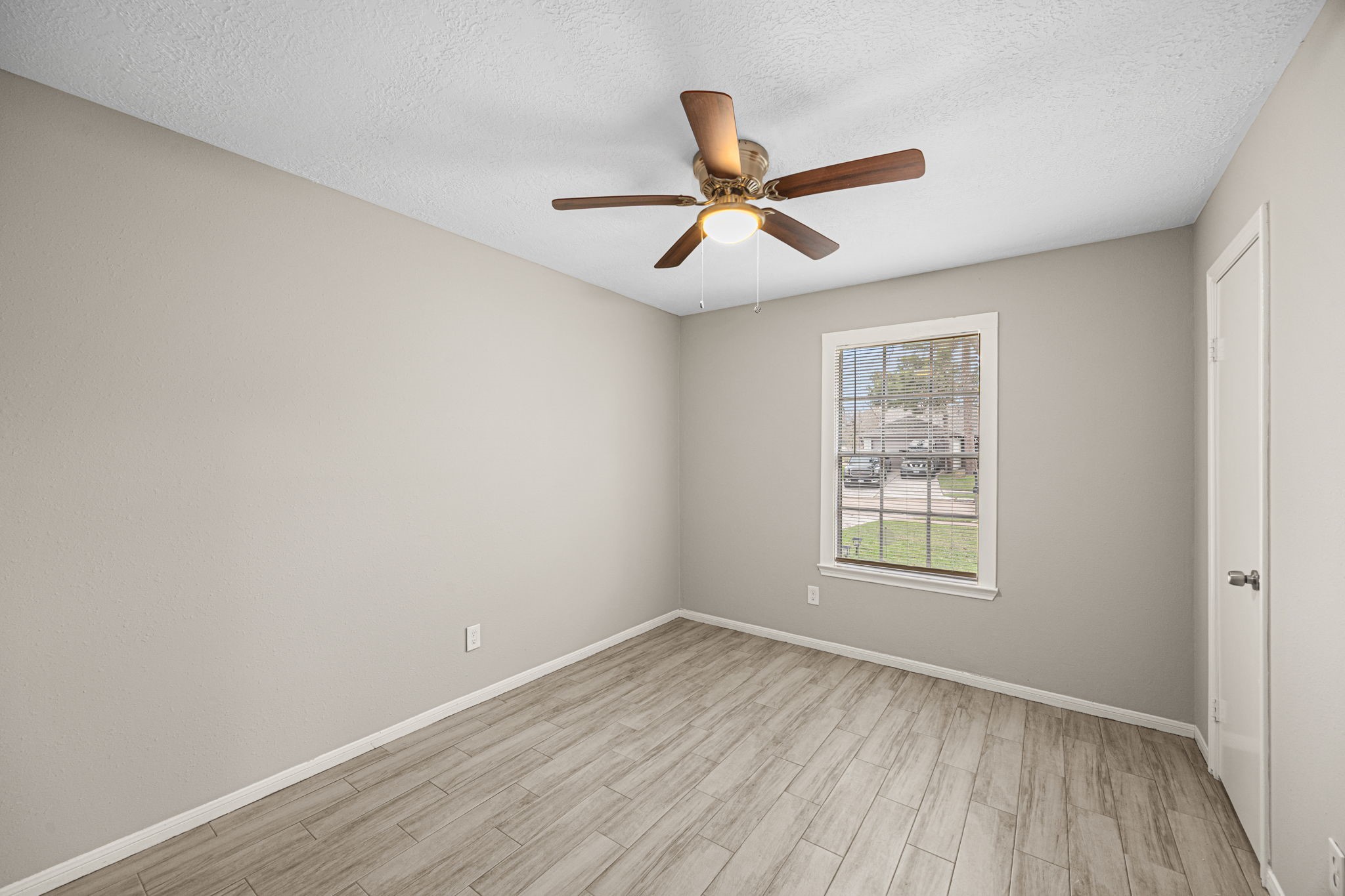 2302 Marble Falls Drive Spring, TX 77373 - Photo 8 of 24 an empty room with wooden floor fan and windows