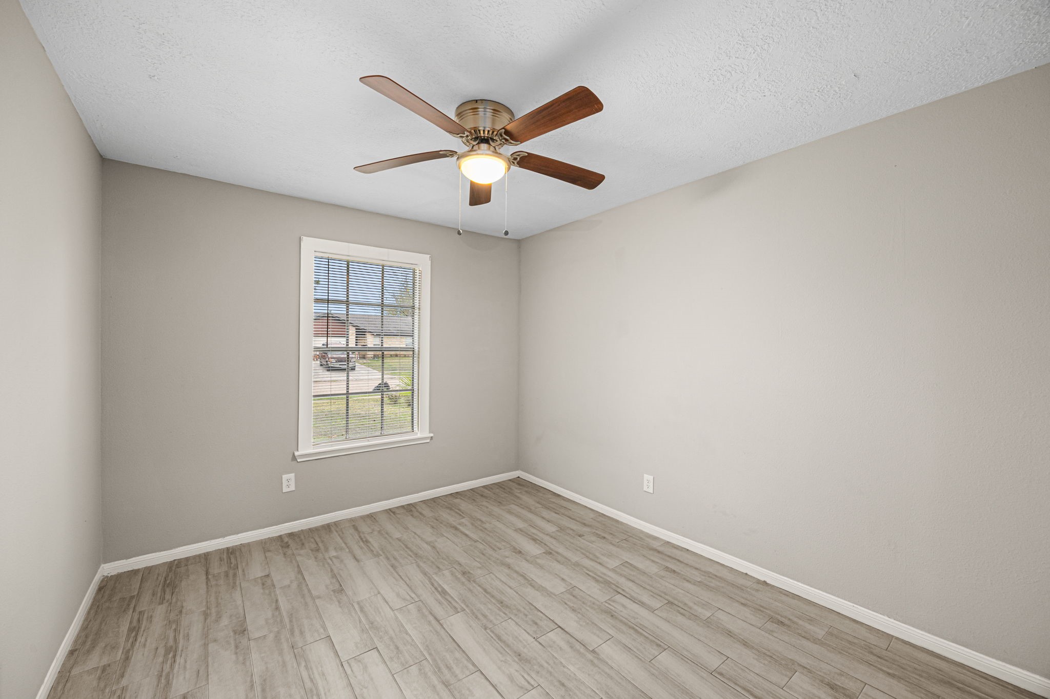 2302 Marble Falls Drive Spring, TX 77373 - Photo 10 of 24 an empty room with wooden floor fan and windows