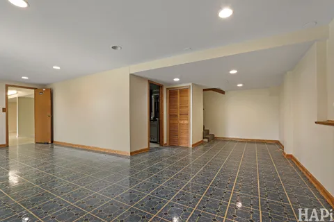 an empty room with wooden floor and natural light