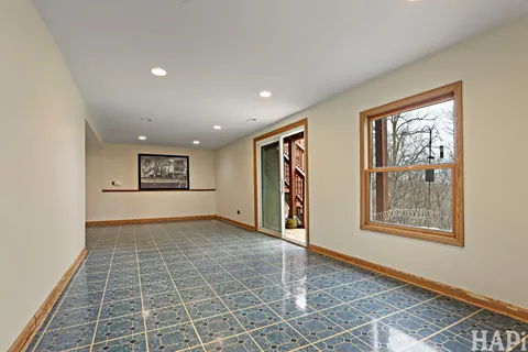 a view of an empty room with a window and a kitchen