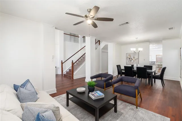 a living room with furniture kitchen view and a potted plant
