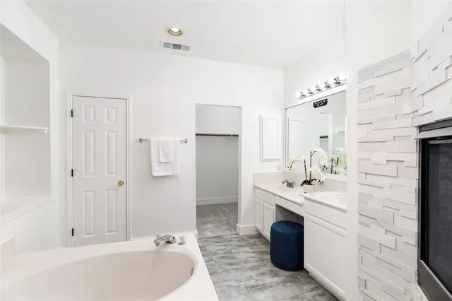 a bathroom with a tub sink and mirror
