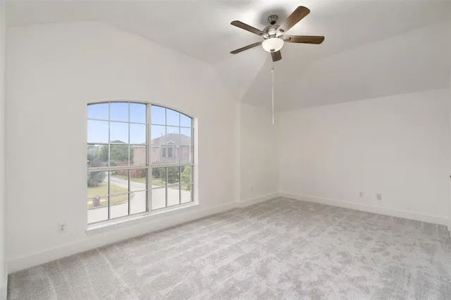 an empty room with a window and a fan